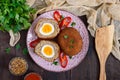 Large juicy cutlets stuffed with boiled egg on a dark wooden background.