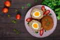 Large juicy cutlets stuffed with boiled egg on a dark wooden background.