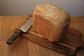 Large kitchen knife and homemade bread on a numbed cutting board cools down, close-up, copy space Royalty Free Stock Photo