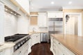 A large kitchen with white cabinets and stainless steel appliances. Royalty Free Stock Photo