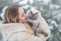 A large labrador dog and a cat in winter on a walk with a young woman in a snowy field Royalty Free Stock Photo