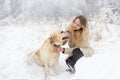 A large labrador dog and a cat in winter on a walk with a young woman in a snowy field Royalty Free Stock Photo