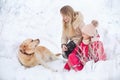 A large labrador dog and a cat in winter on a walk with a young woman in a snowy field Royalty Free Stock Photo