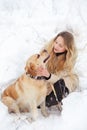 A large labrador dog and a cat in winter on a walk with a young woman in a snowy field Royalty Free Stock Photo