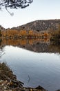 Large lake reflecting autumn trees colors and the mountain Royalty Free Stock Photo