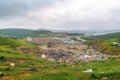 large landfill, with rows of garbage and recycling bins, surrounded by green landscape