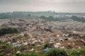 large landfill, with rows of garbage and recycling bins, surrounded by green landscape