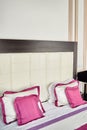 Large leather headboard of luxury bed, white and pink pillows on it, copy space. Feminine bedroom. Checkered soft headboard Royalty Free Stock Photo