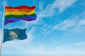 large lgbt flag and flag of South Dakota state, USA waving in the wind at cloudy sky. Freedom and love concept. Pride month.