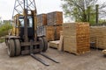 Large lift truck and stacks of new wooden boards and studs at th Royalty Free Stock Photo