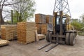 Large lift truck and stacks of new wooden boards and studs at th Royalty Free Stock Photo