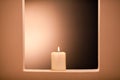 Large lighted candle on a shade background