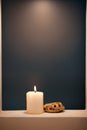 Large lighted candle on a shade blue background