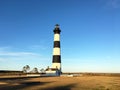 Striped lighthouse set against the blue sky Royalty Free Stock Photo