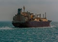 A large liquid Natural Gas tanker sailing ahead into the sunset in the Singapore Straits in Asia