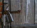 A large lock hangs on an old wooden barn door.