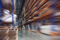 Large Logistics hangar warehouse with lots shelves or racks with pallets of goods, blurred motion effect