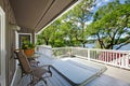Large long balcony home exterior with hot tub and chairs, lake view. Royalty Free Stock Photo