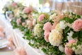 A large, long, decorated table , covered with a white tablecloth with dishes, flowers. Wedding banquet. close up Royalty Free Stock Photo