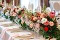 A large, long, decorated table , covered with a white tablecloth with dishes, flowers. Wedding banquet. close up Royalty Free Stock Photo