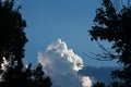 LARGE LOOMIMG CUMULUS CLOUDS IN BLUE SKY WITH TREES IN SILHOUETTE Royalty Free Stock Photo