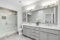 A large, luxurious bathroom with a marble shower and grey vanity. Royalty Free Stock Photo