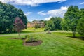 large, luxurious, brick house with landscaping and a huge green lawn. Landscape on a summer sunny day under a blue cloudy sky