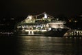 Large luxury cruise ship on sea water at night with illuminated light docked at port of Stockholm