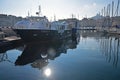 Large luxury yacht and a row of sails docking mooring at Marseille old town harbor port on a blue sky calm day, Southern France Royalty Free Stock Photo