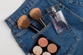 Large makeup brushes in a pocket of blue jeans. Concept, commercial work of a makeup artist, for printing business cards and