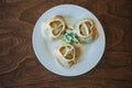 Large manti on a white dish with sour cream and herbs. Eastern cuisine. Meat in dough. Stands on a wooden table Royalty Free Stock Photo