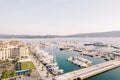 Large marina with rows of yachts moored off the shore with expensive hotels. Porto, Montenegro. Drone