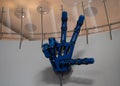 A large mechanical hand at a robot exhibition shows a sign of victory. The robotic arm is controlled by special levers