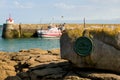 A large medallion fixed to a rock in the harbour of Barfleur, Normandy, France