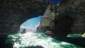 A large medieval ship on a Sunny day sails from a deserted rocky island. 3D Rendering