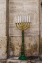Large menorah lampstand, Judaism religious symbol with star of David decoration, standing against marble walls background