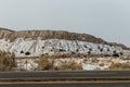 Large mesa plateau with snow on side of empty highway in rural New Mexico