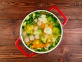 Large metal cast red pan with delicious hot soup of vegetables a Royalty Free Stock Photo