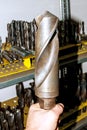 A large metal drill in the hand. Drilling and milling industry.