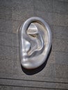 Large metal ear on the granite facade of the house