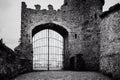 Large metal gate medieval stone castle door in black and white.