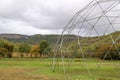 Large metal geodesic dome greenhouse structure in a rural setting with hills in the background Royalty Free Stock Photo