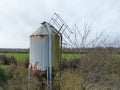 Large, metal grain feed silo showing a  poor state of repair. Royalty Free Stock Photo