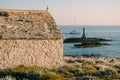 A large metal green lighthouse on a rock in the sea, near Cape Punta Planka in Croatia.