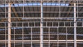 Large metal industrial factory building structure with corrugated steel curve roof and skylights in construction site area