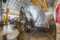 A large metal oil rig propeller in an industrial warehouse along w