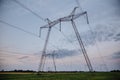 Large metal supports of power lines passing through agrarian fields. High voltage lines