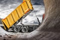 A large mining truck unloads the earth. A soil transporter with a raised body dumps soil. Contrast image against the sunset sky.