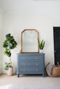 Large mirror placed atop of dresser in the corner of bedroom