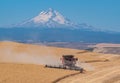 Harvesting wheat in front of Mt Hood in Wasco County Oregon Royalty Free Stock Photo